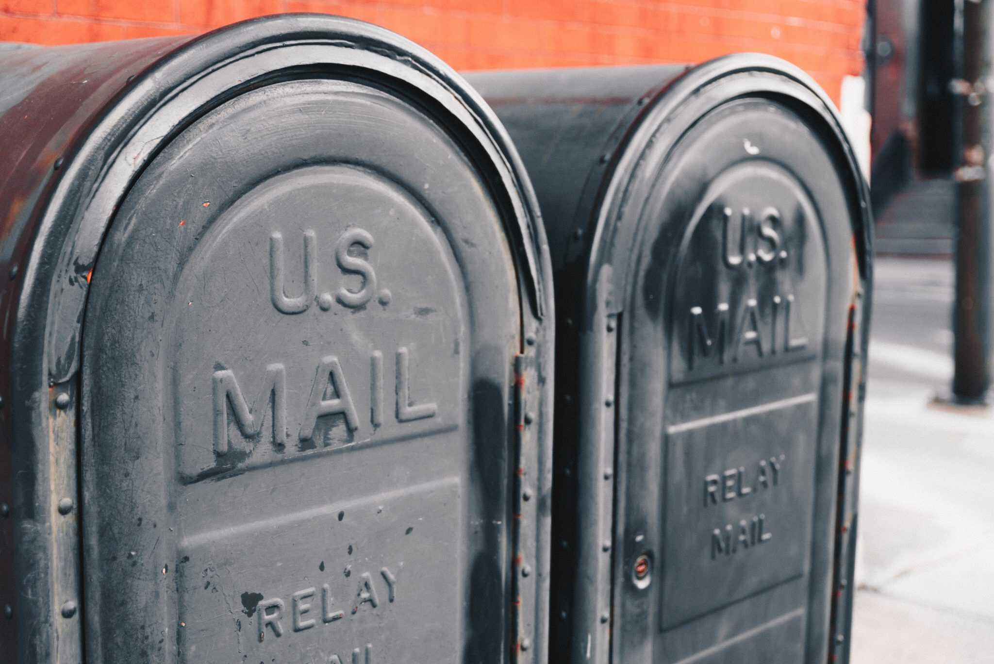 Two black curbside mailboxes side-by-side